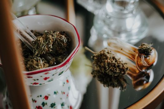 Detailed shot of cannabis buds in a bowl with a pipe, ideal for medical use concepts.