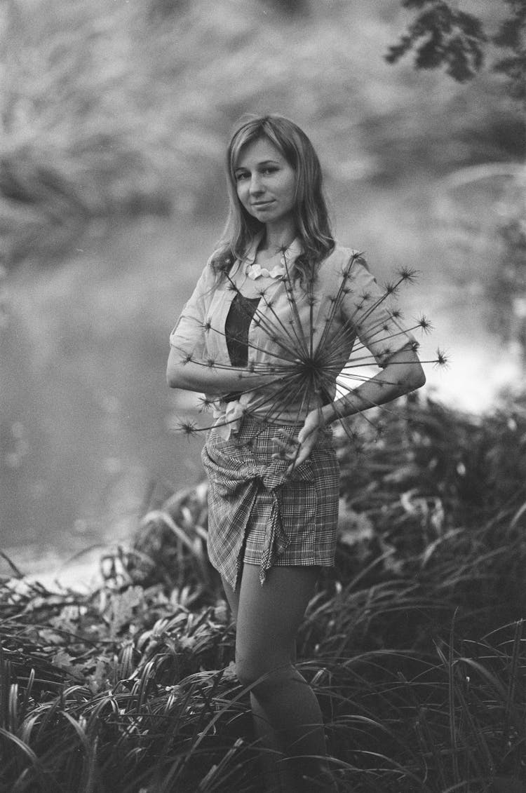 Woman With Plant Standing In Nature