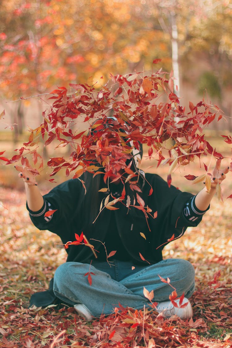 Woman Playing With Leaves In The Park