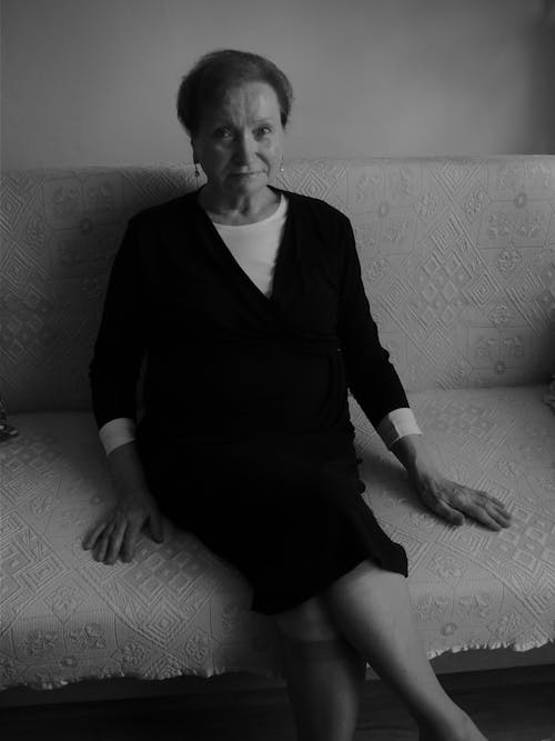 Black and White Photograph of a Senior Woman Sitting on a Sofa