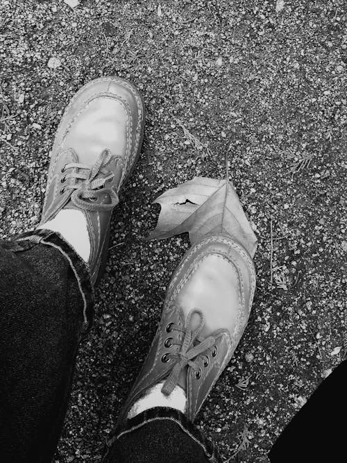 Black and White Photo of Legs in Shoes, Standing on a Ground