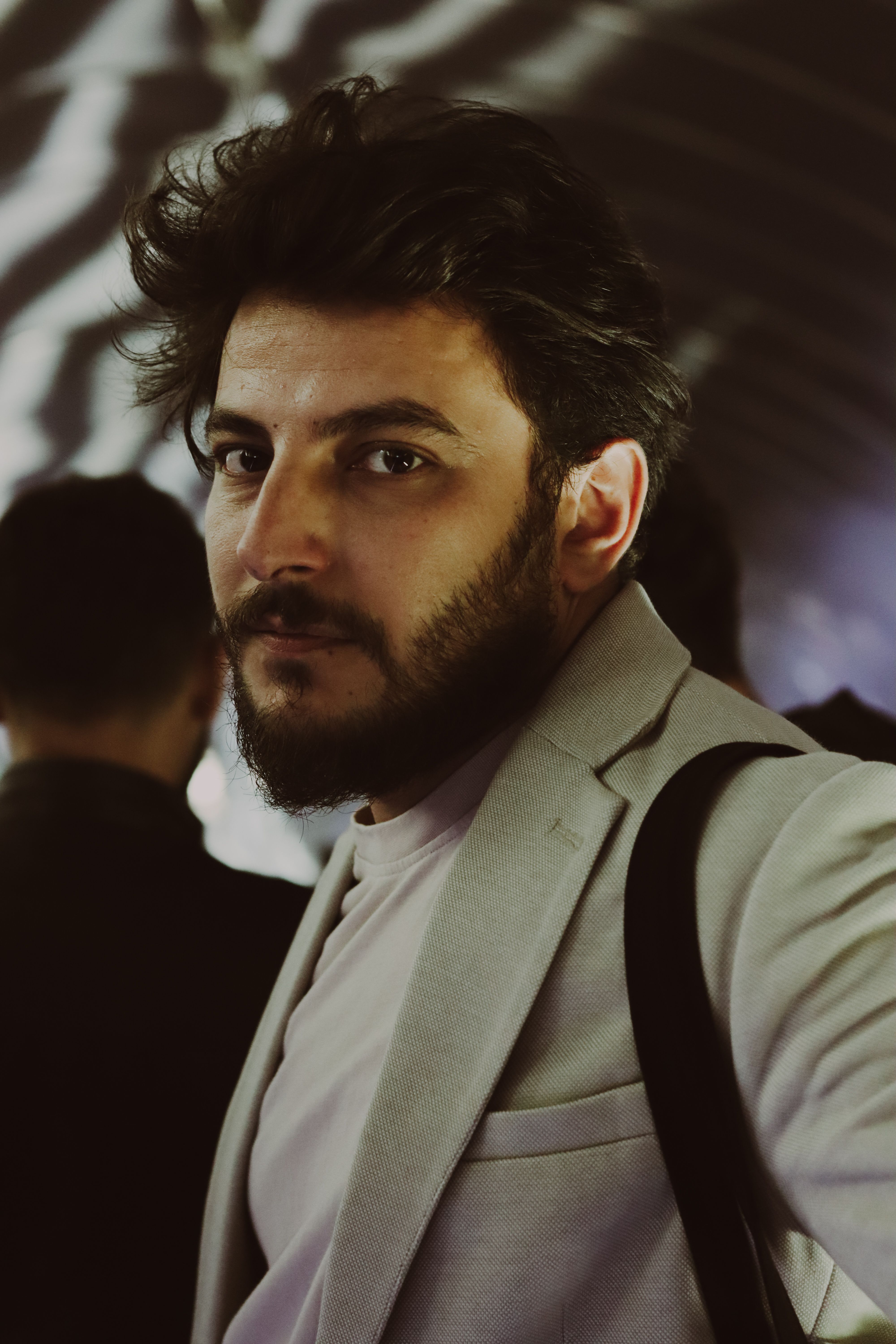 Portrait of a stylish man with a beard in a tunnel, exuding elegance and fashion.