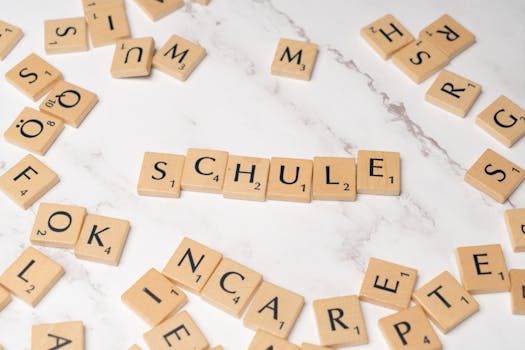 Scrabble letter tiles spelling 'Schule' on a marble surface, ideal for language learning concepts.
