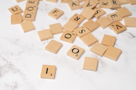 Wooden letter tiles scattered on a marble surface, ideal for educational and language development themes.