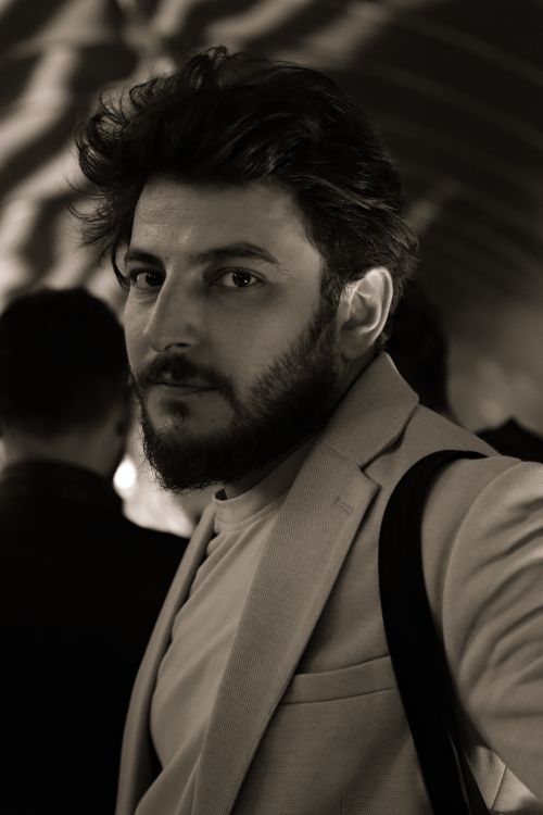 Free Sepia-toned portrait of a bearded man wearing a suit, in a stylish and moody setting. Stock Photo