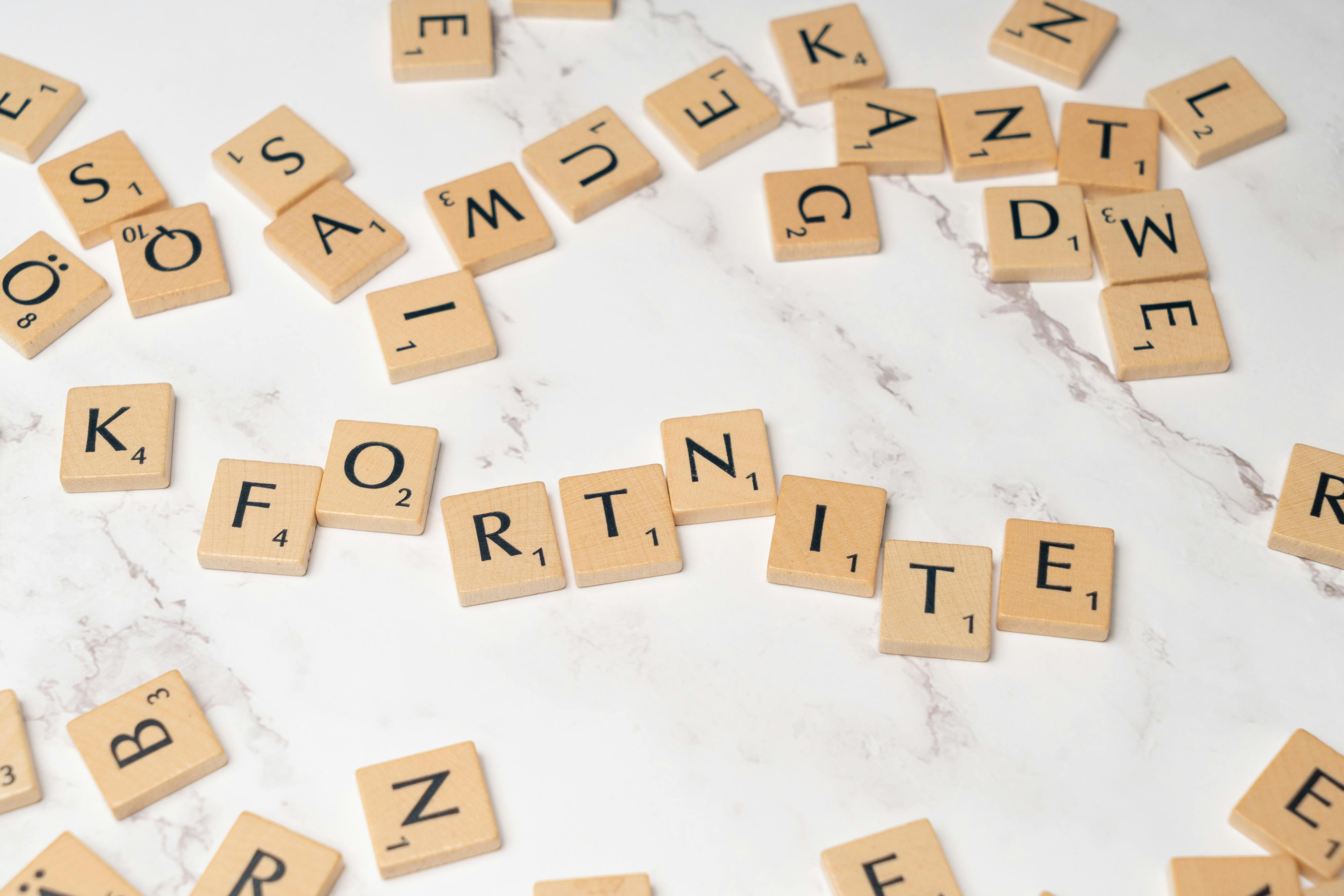 scrabble letters spelling fortnite on a marble table