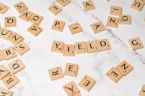 Scrabble letters spelling yield on a white table