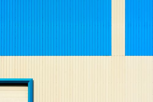 Free Abstract image of a blue and beige corrugated building wall featuring geometric patterns. Stock Photo