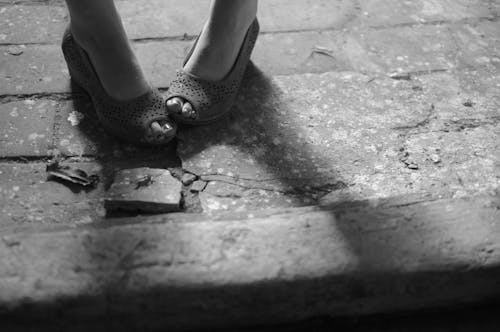 Woman in Leather Shoes Standing on Stone Ground