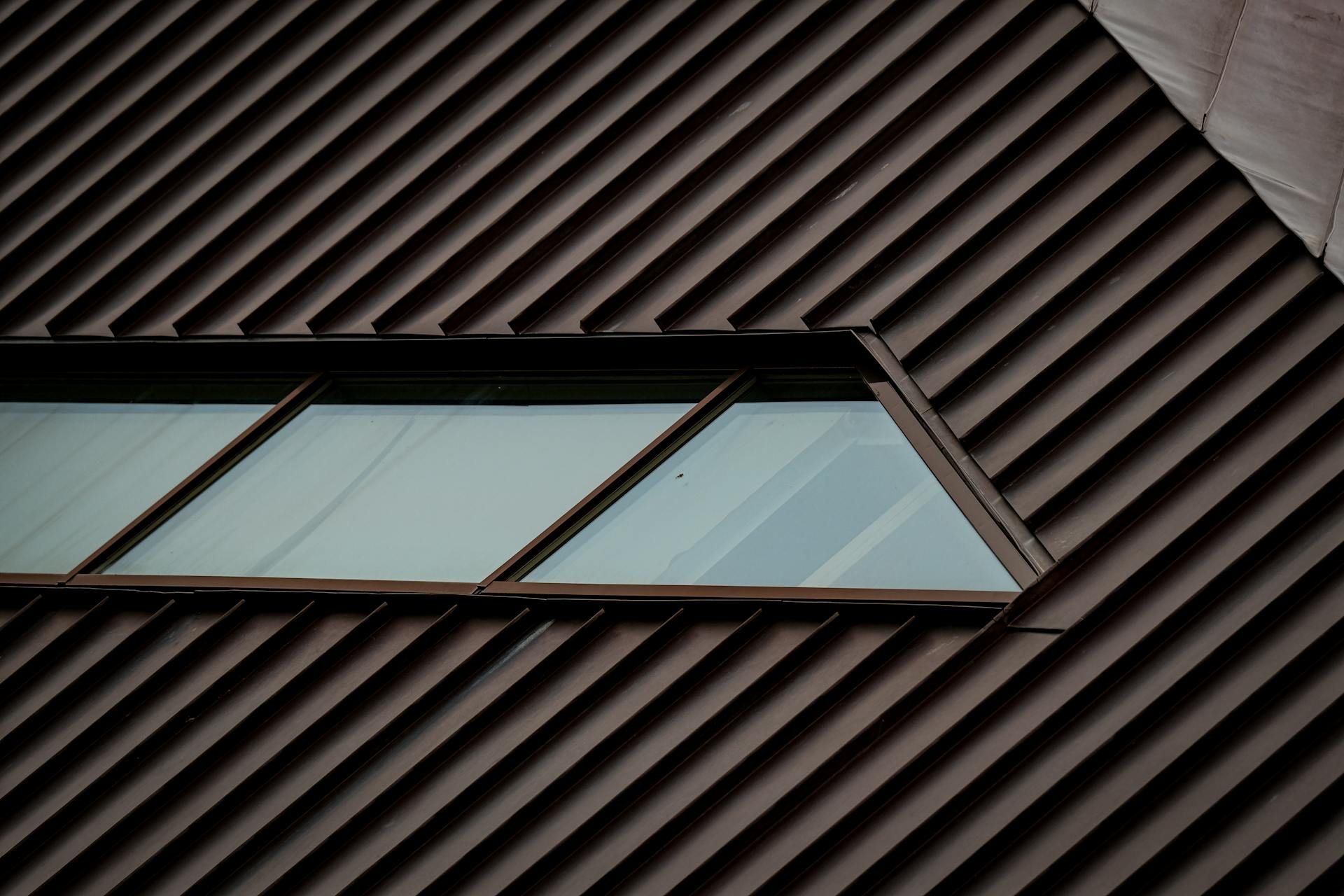 Close-up of a modern roof with geometric window design, highlighting metal texture.