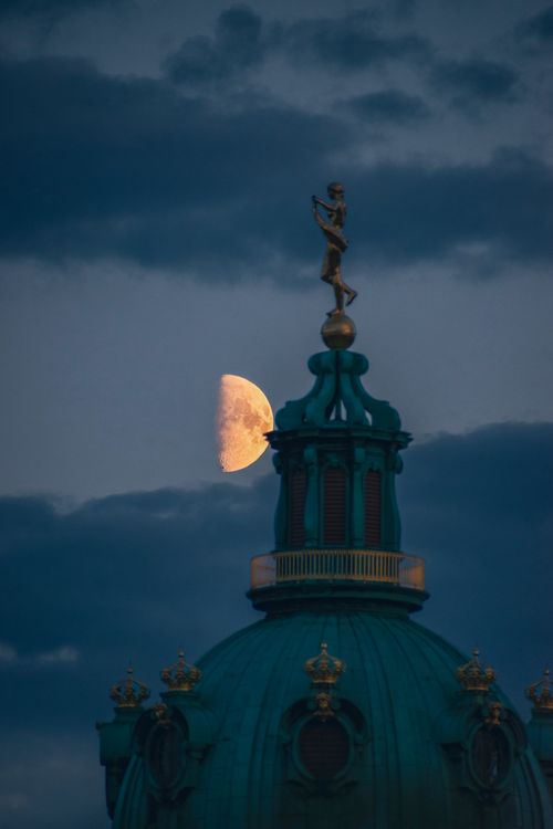 Free Dramatic crescent moon rising over the historic dome of a Berlin palace against a twilight sky. Stock Photo