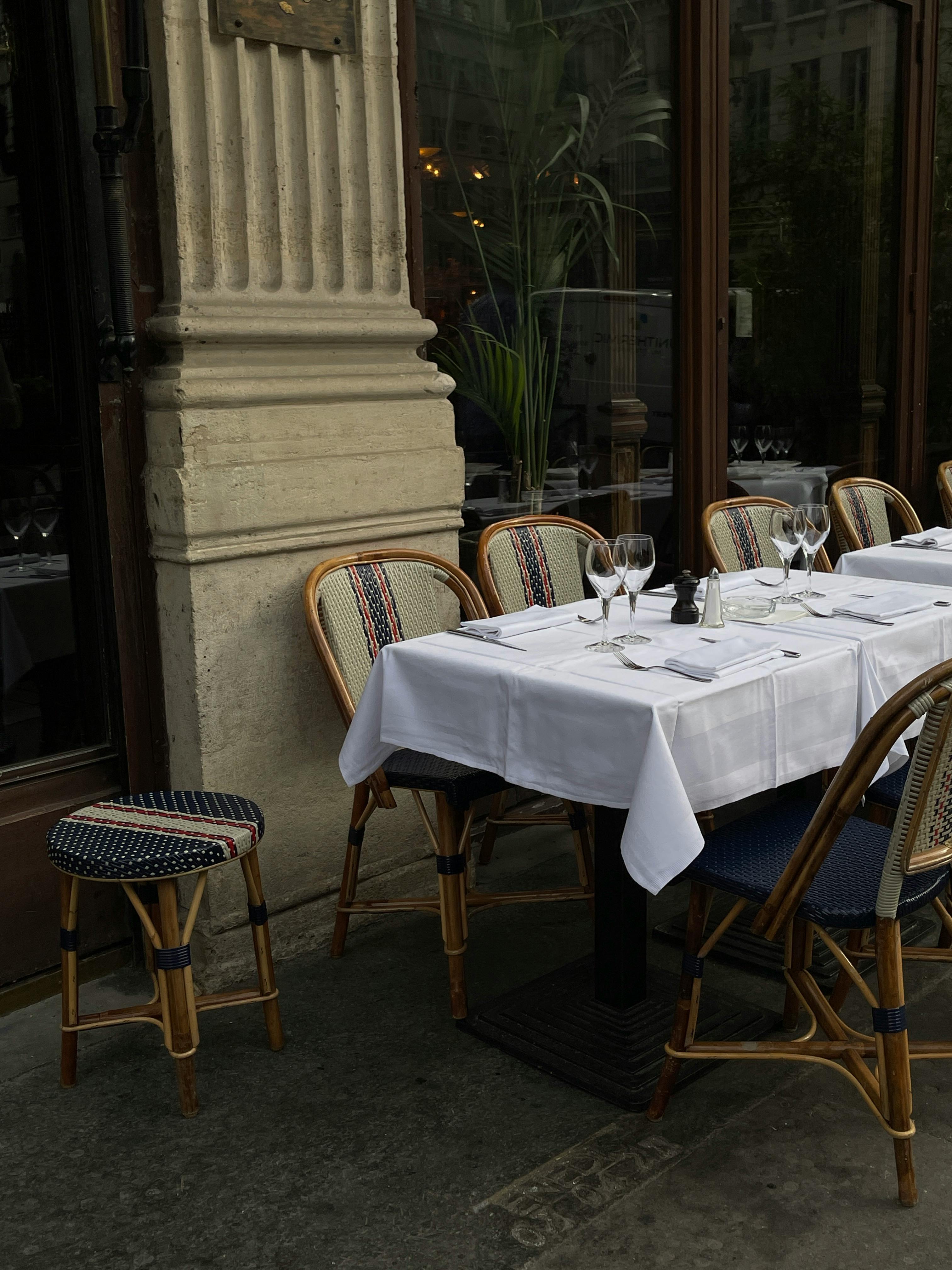Charming outdoor restaurant setup with tables and chairs on a city sidewalk, ready for dining.