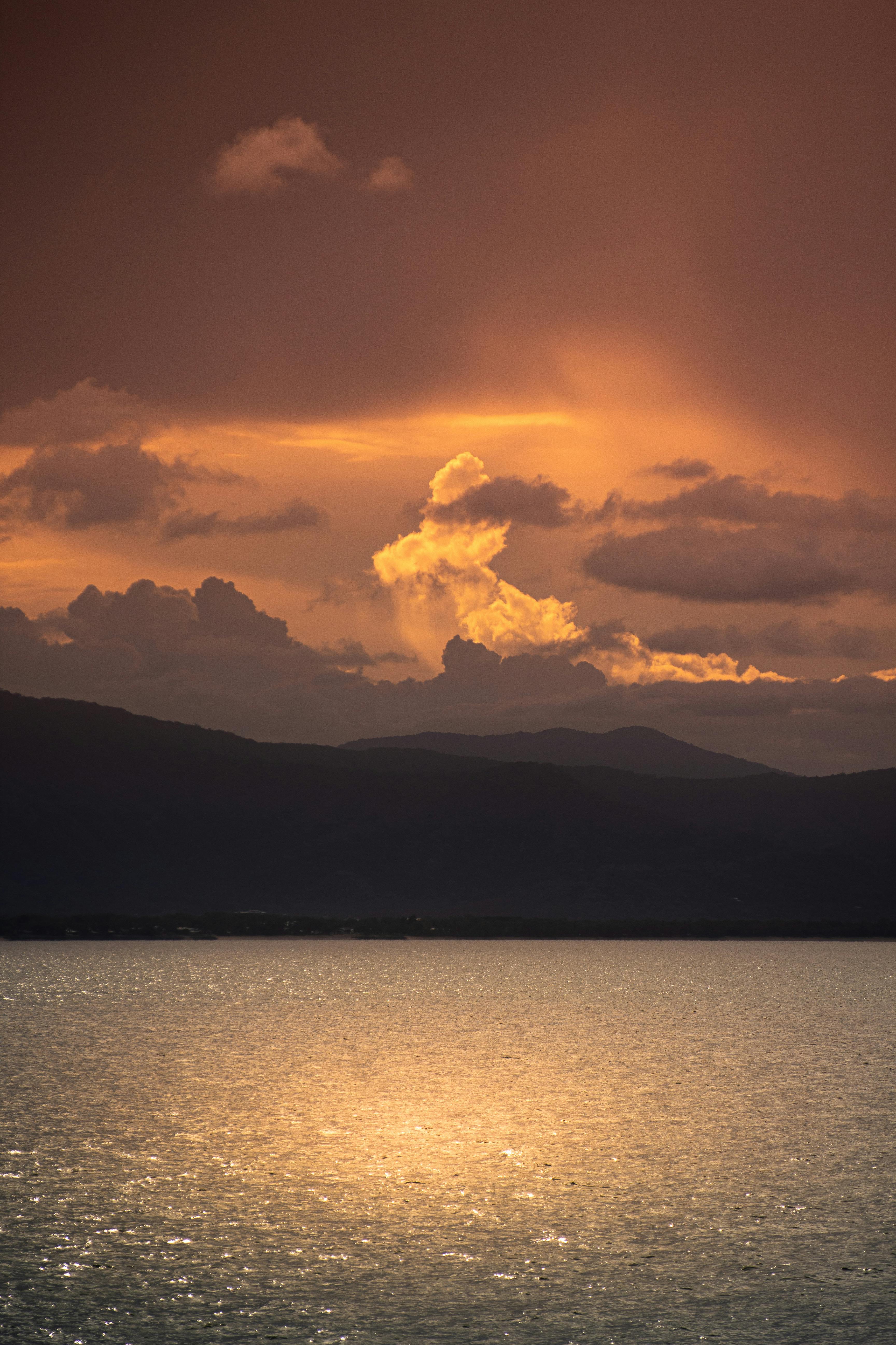A stunning sunset over an Australian bay with dramatic clouds reflecting on the sea.
