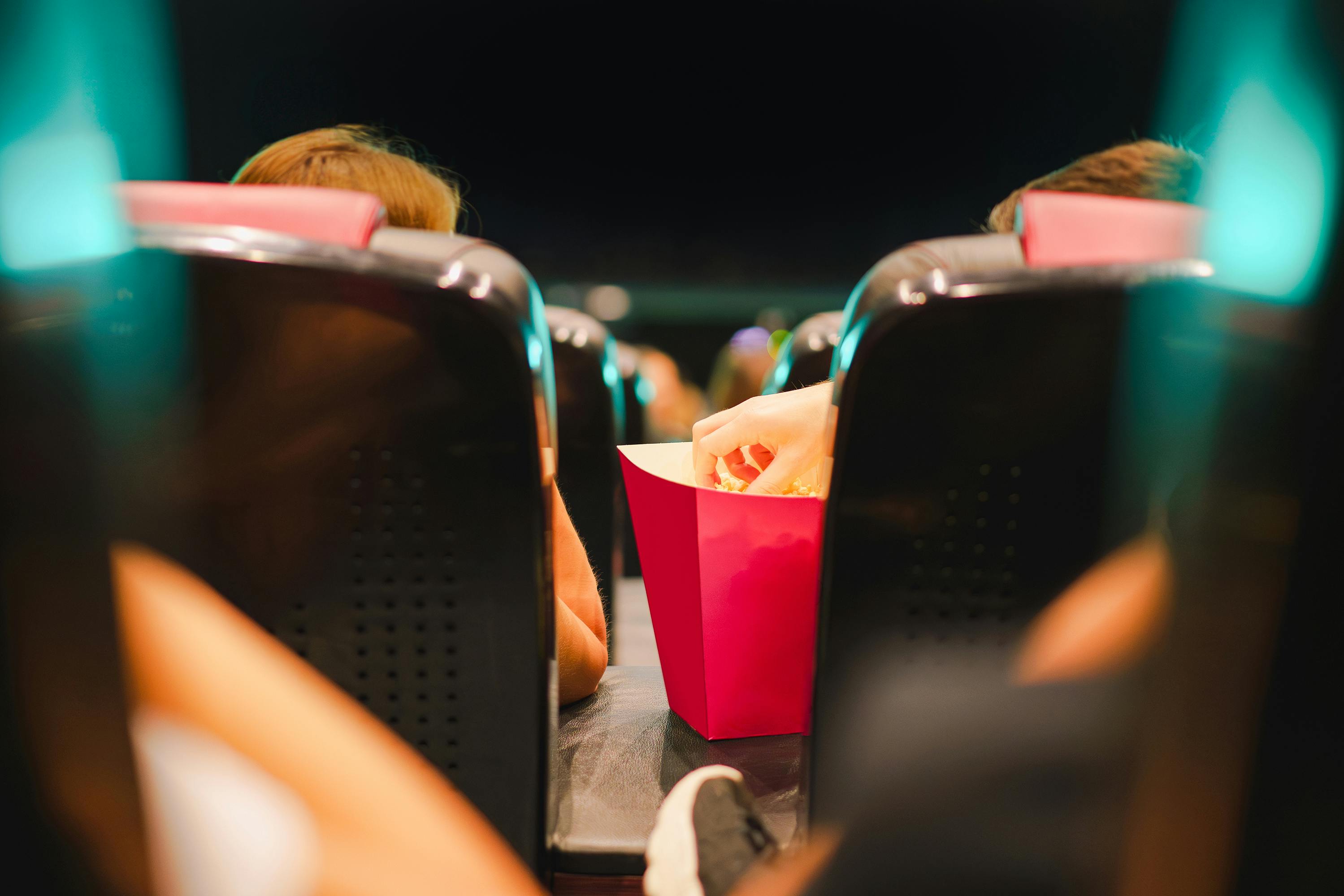 cinema audience hand catching popcorn from a box