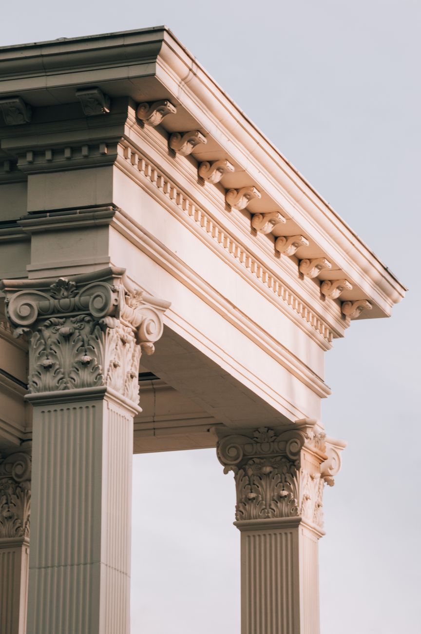 Close-up of neoclassical corinthian architecture captured at sunset, showcasing intricate carvings.