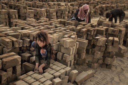 Little Girl Stacking Bricks with Adults