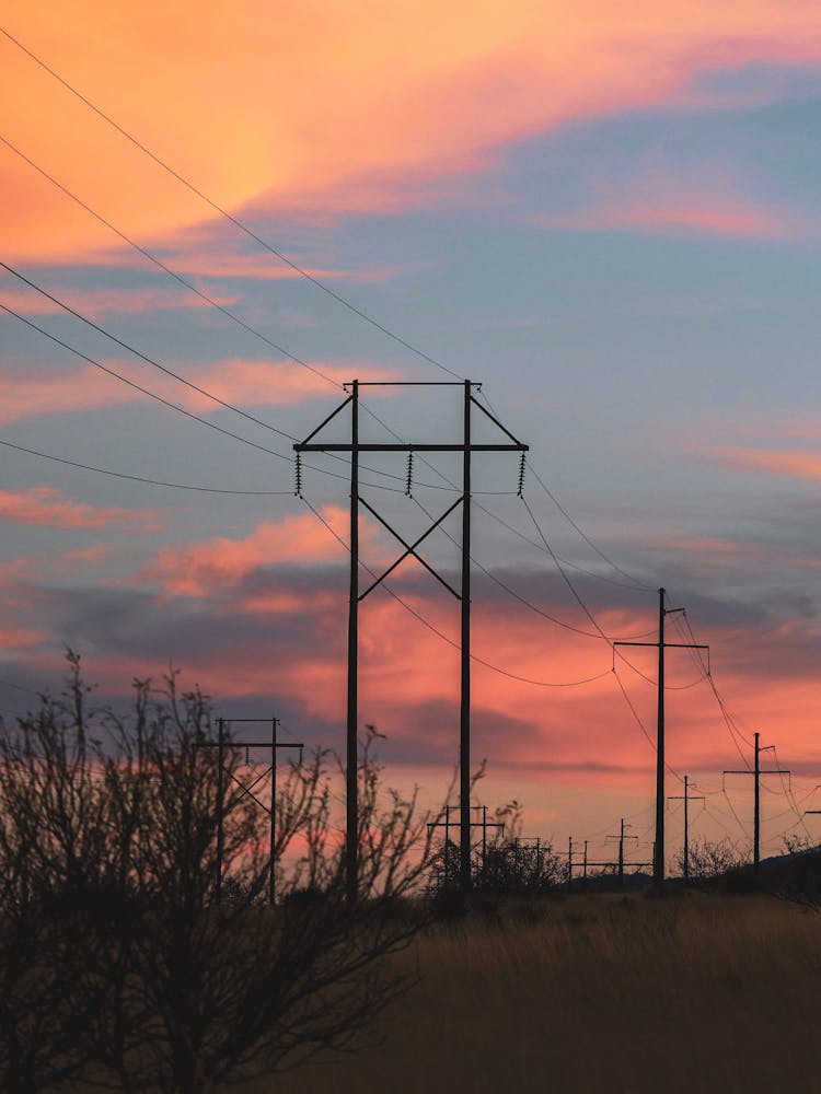 Transmission Poles And Overhead Power Lines At Dusk