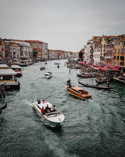 Multiple Boats on Canal in City