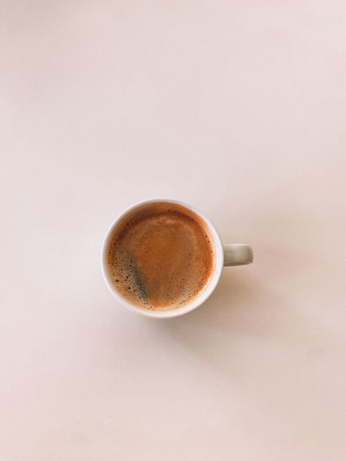 Free Aerial shot of a single mug filled with coffee, showcasing a minimalist aesthetic. Stock Photo