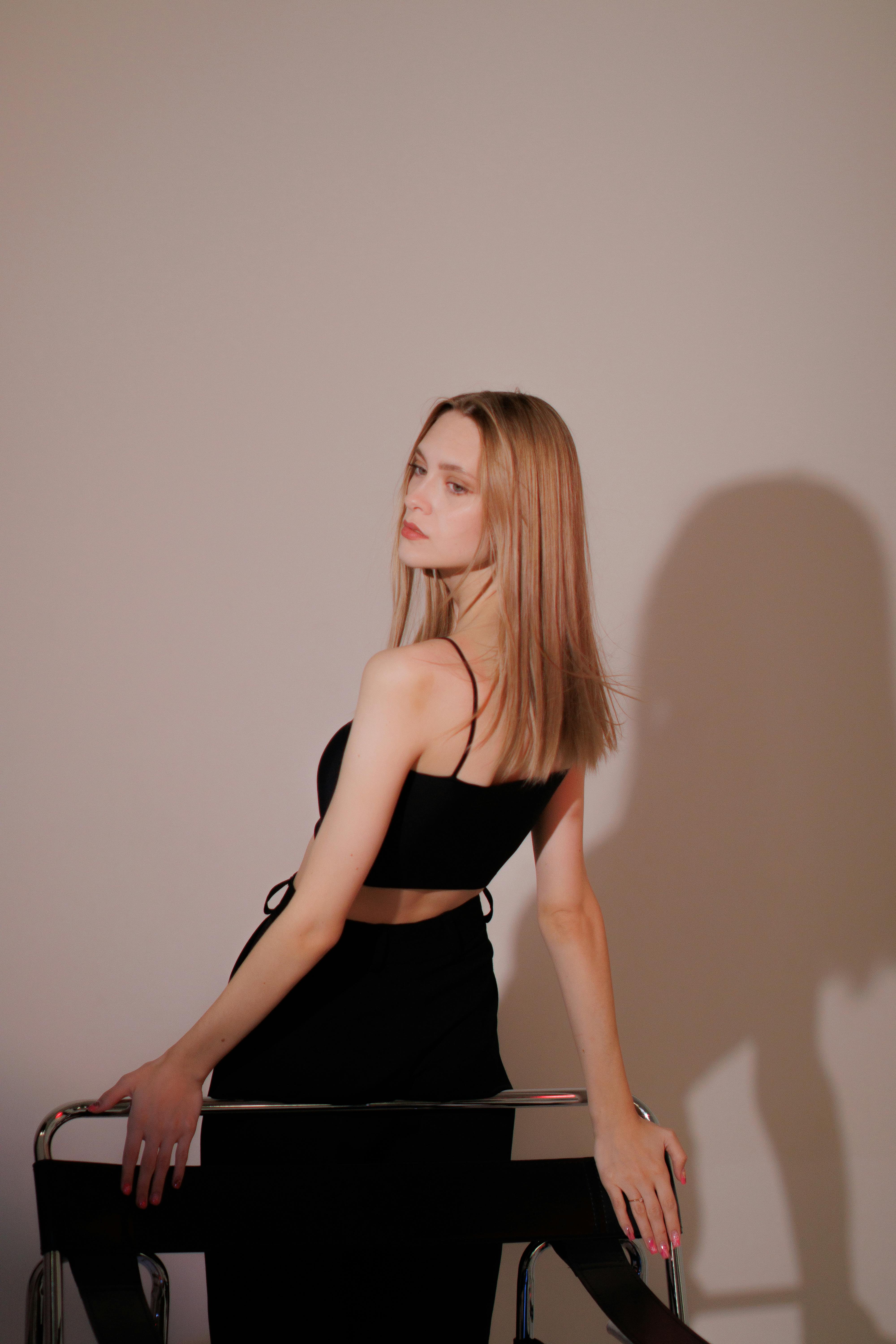 Elegant studio shot of a blonde woman posing confidently in stylish attire.