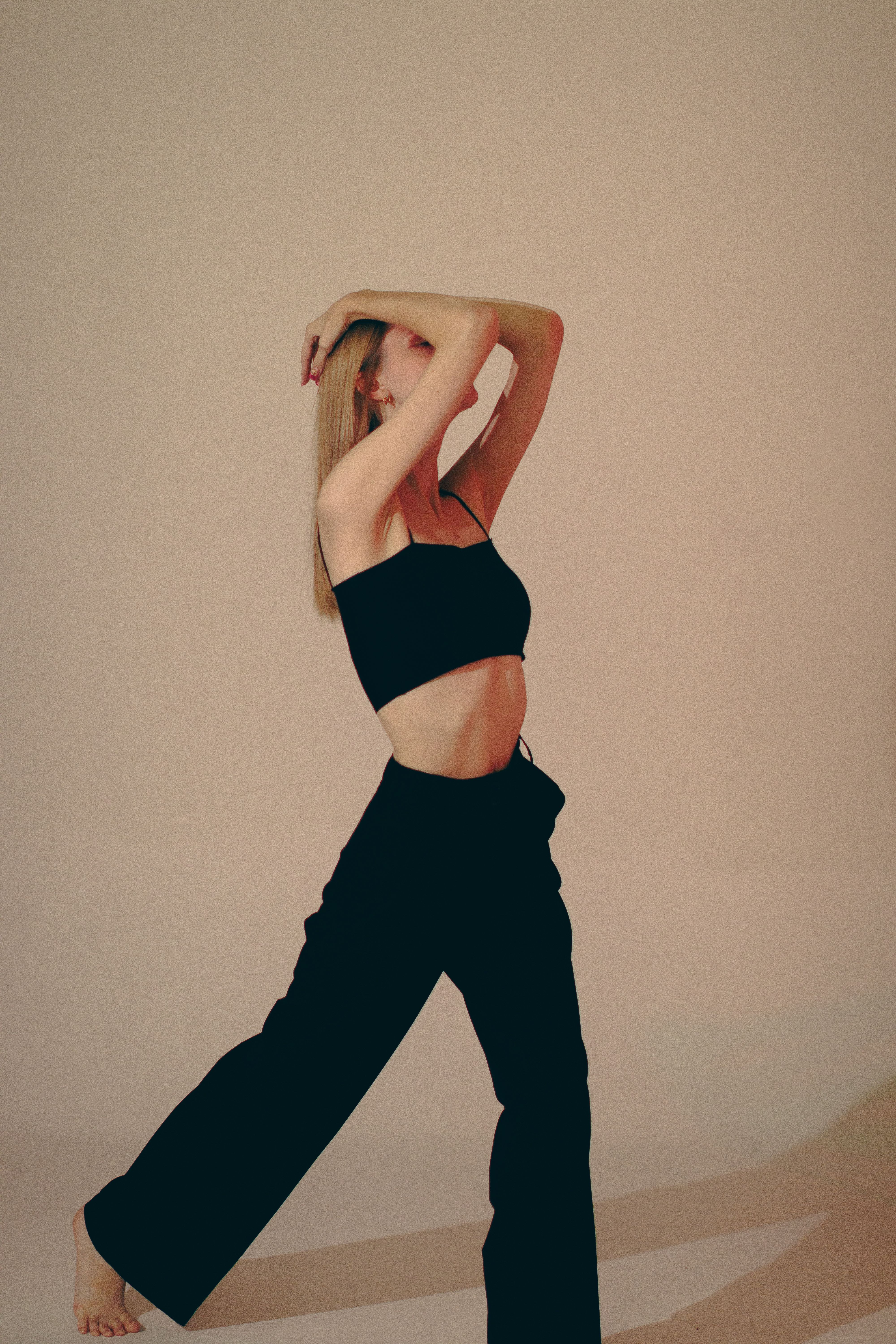 Elegant fashion studio shot of a woman posing gracefully in chic attire.