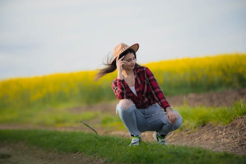 Woman in Hat and Shirt Posing on Field