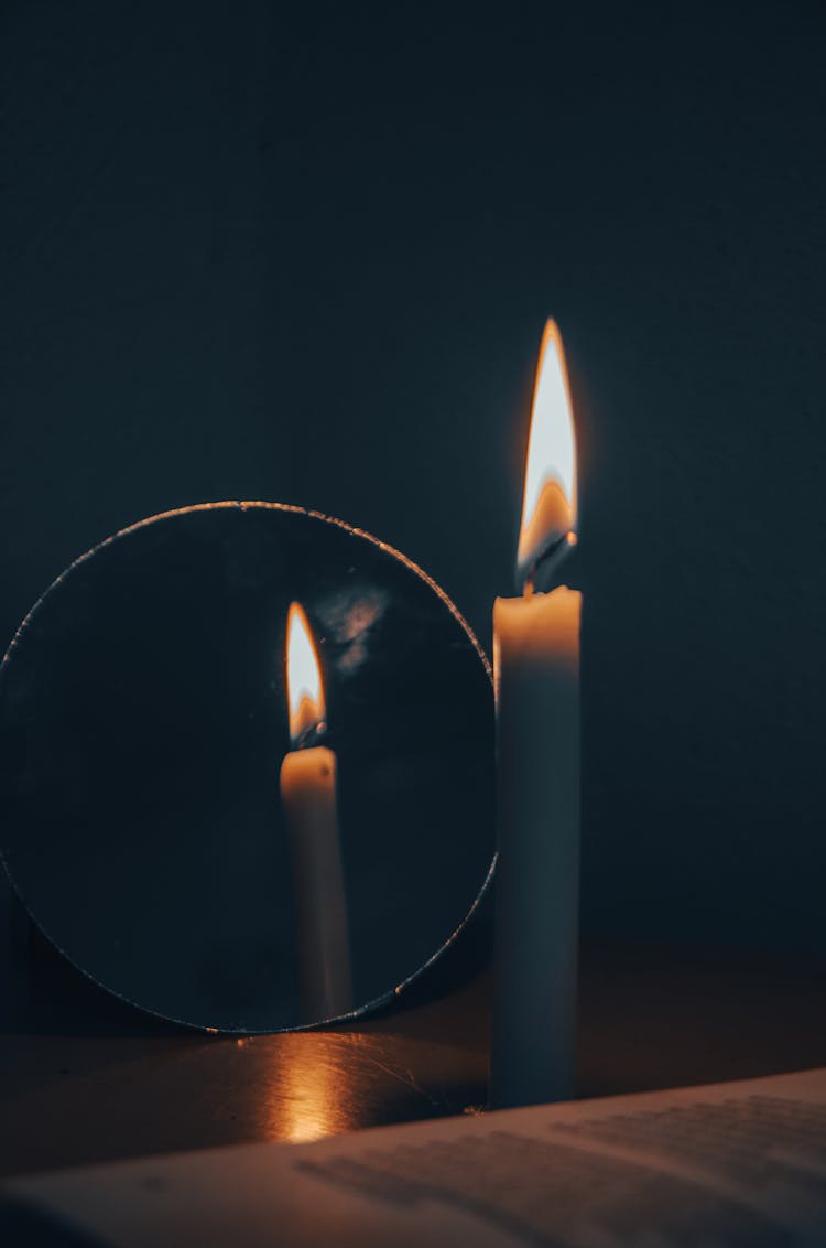 Lit Candle Next To A Mirror 