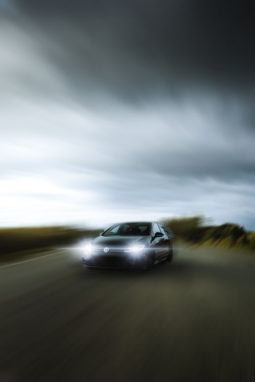 Free Experience the speed and thrill of a car in motion on a scenic road, captured with dynamic motion blur. Stock Photo