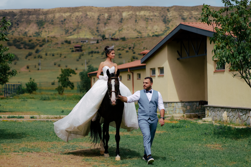 Free Bride on horseback with groom in countryside setting, perfect wedding moment. Stock Photo