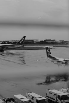 Monochrome photo of airplanes on an airport runway with a moody atmosphere.