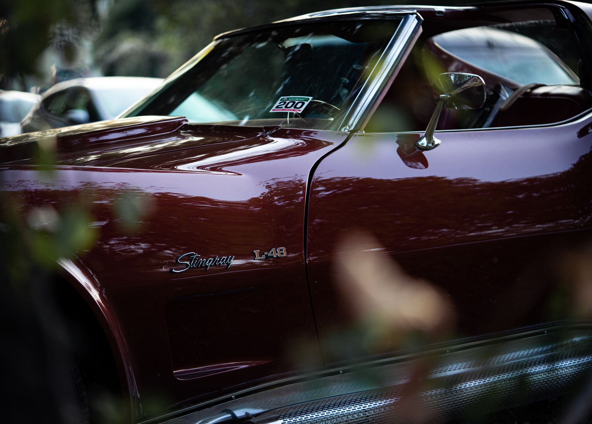 Detailed close-up of a red vintage Chevrolet Corvette Stingray L-48 showcasing classic car design.