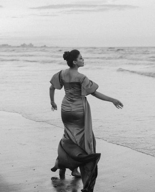 Elegant Woman in Dress Standing on Beach