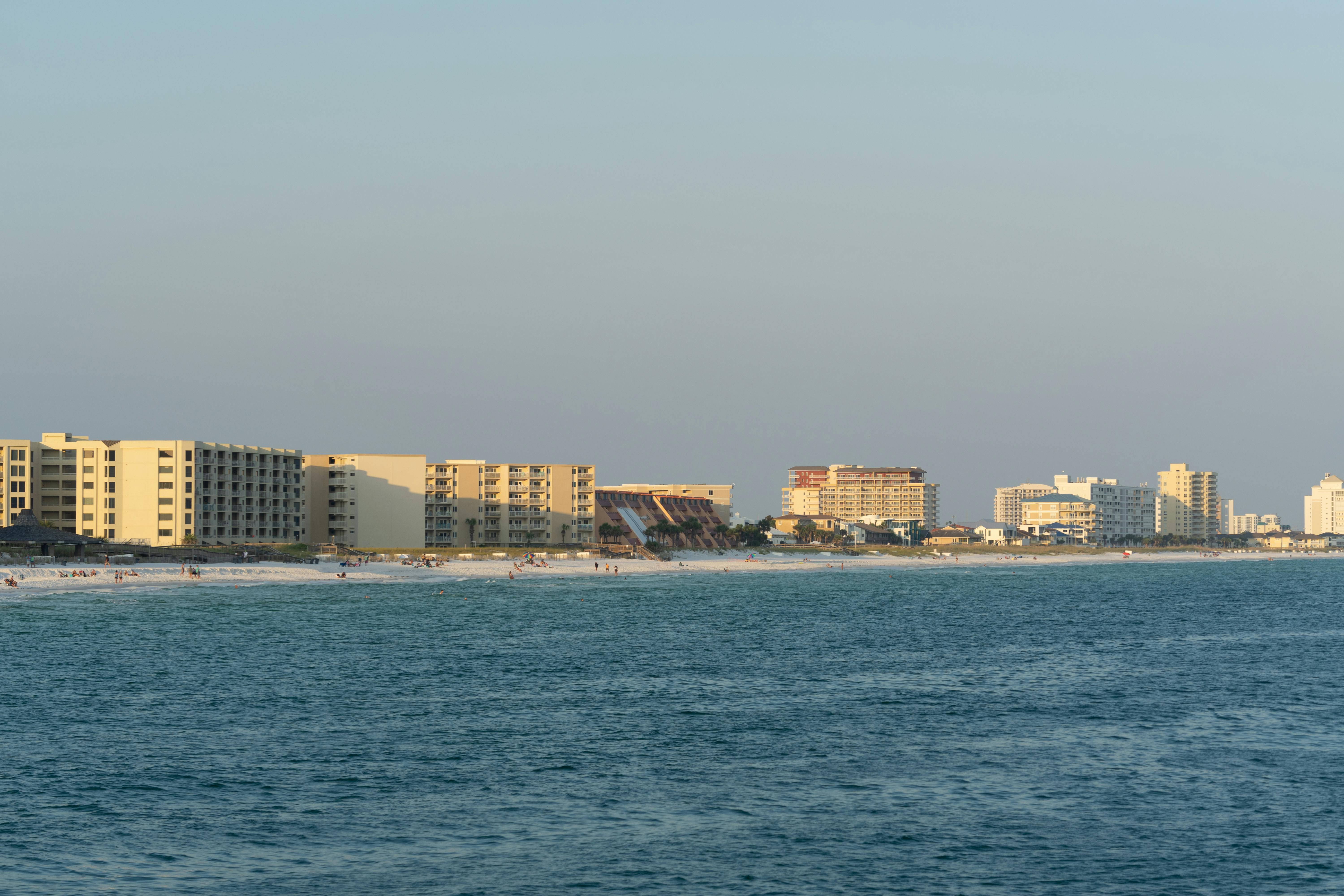 Sunset view of Destin, FL beachfront with modern architecture and serene ocean.