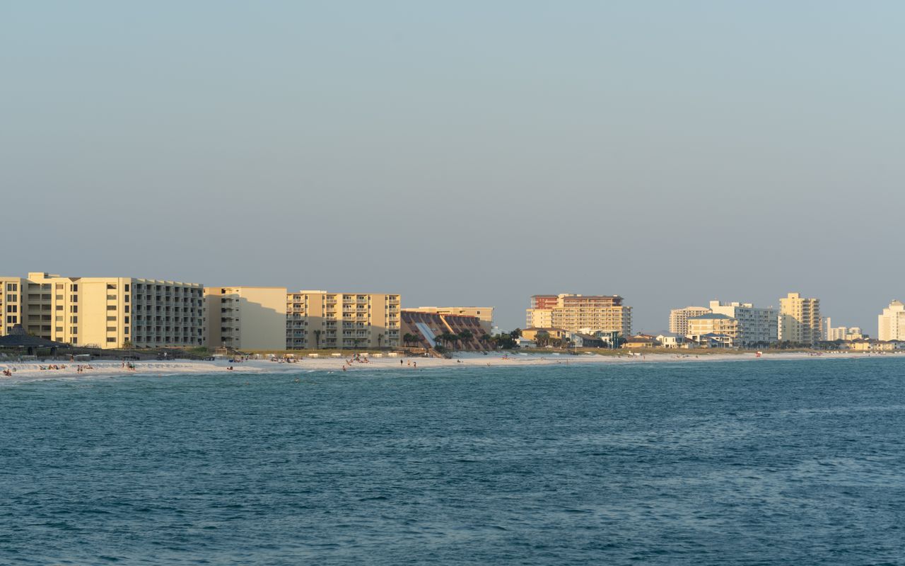 Sunset view of Destin, FL beachfront with modern architecture and serene ocean.