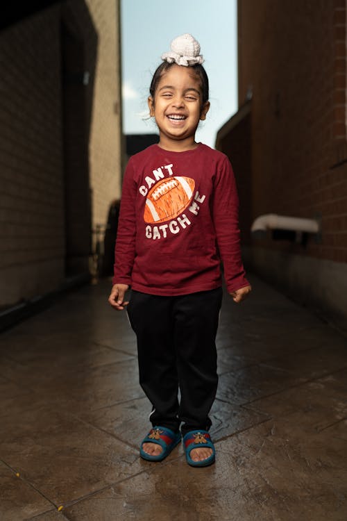 Free A young boy wearing a red shirt and black pants Stock Photo
