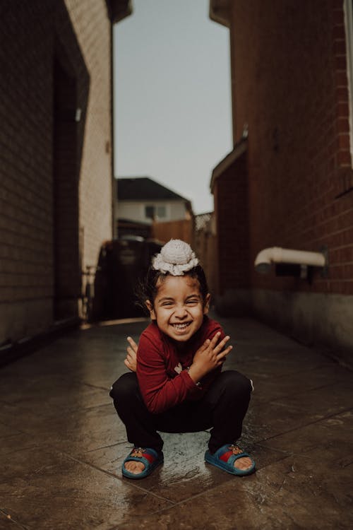 Free A young boy crouches down in an alleyway Stock Photo