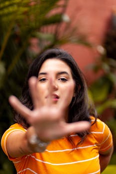 一位年轻女子的特写肖像，色彩鲜艳，她正在用手做手势