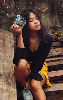 一位年轻女子在户外手持模拟相机，摆出复古风格的姿势
