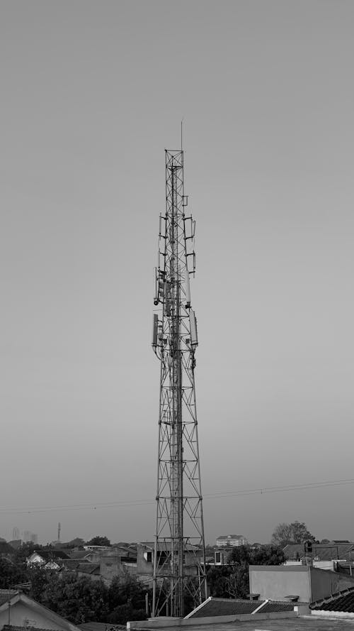Black and White Photo of a TV Tower and Houses 
