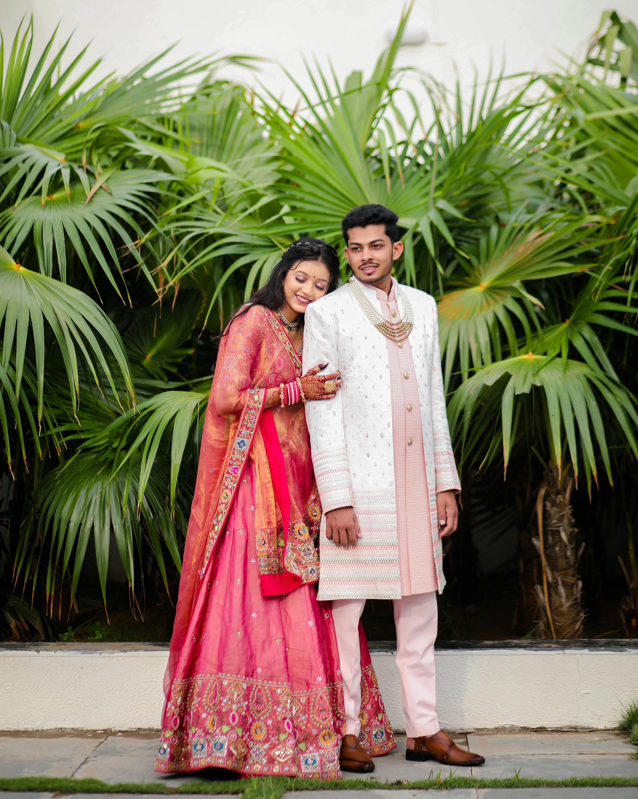 A joyful Indian bride and groom embrace during a vibrant outdoor wedding ceremony.