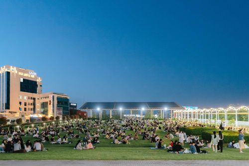 Free A vibrant evening event in an illuminated urban park in Gwangju, South Korea, with people enjoying leisure activities. Stock Photo