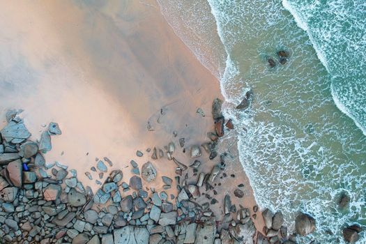 A stunning aerial view of Kijal's sandy beach with rocks and turquoise waves.