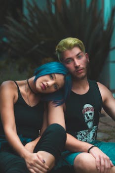 一对时尚的年轻夫妇在户外合影，他们大胆地染着蓝色和金色的发型