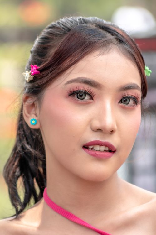 Free Vibrant portrait of a young woman with makeup and colorful hair accessories. Stock Photo