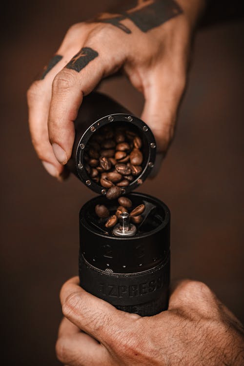 Man Pouring Coffee Beans into a Grinder