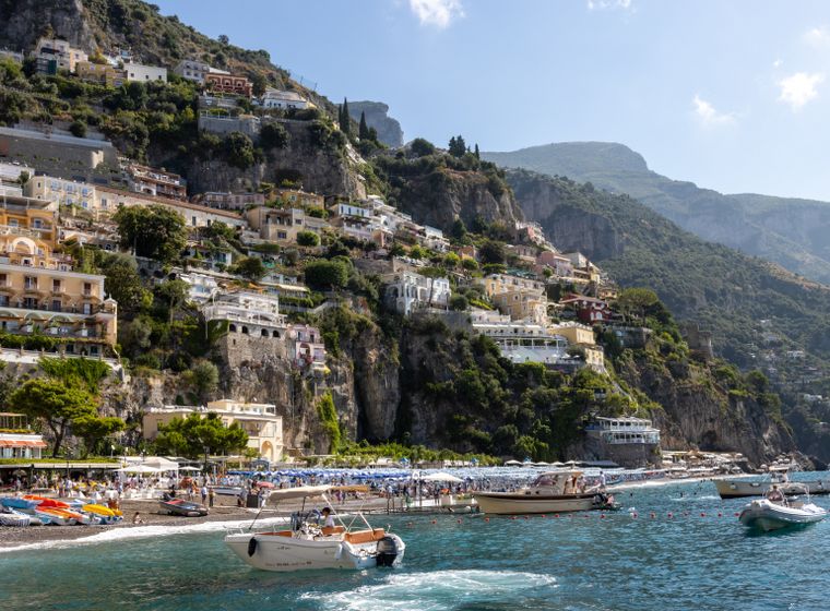 Positano's pastel houses stacked above the sea at midday
