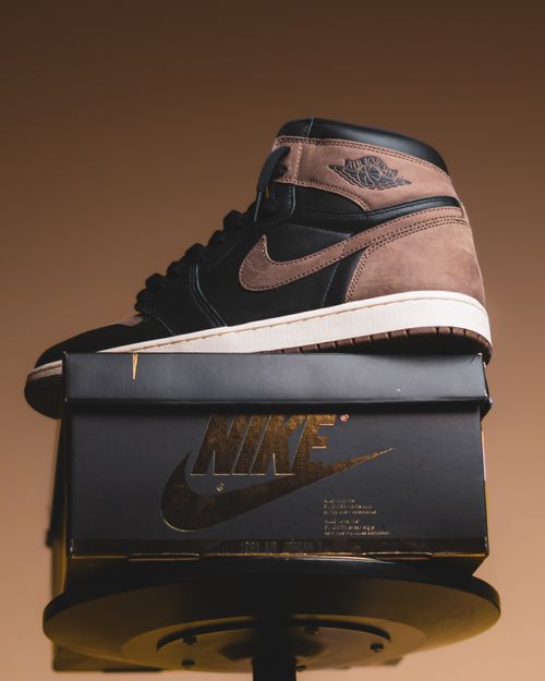 Free Close-up of black and brown sneakers on a branded box in studio lighting. Stock Photo