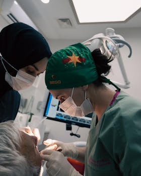 Dentists with masks and gloves attending to a patient in a modern dental office.