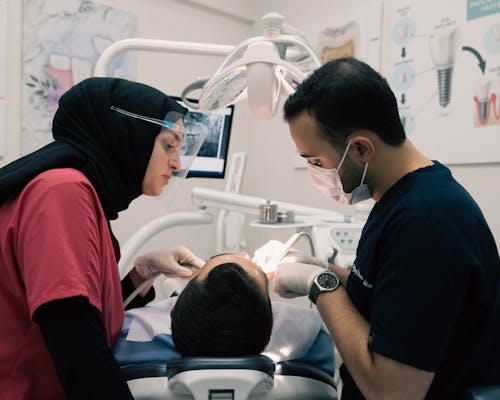 Dentist and a Nurse Treating a Patient in a Dental Clinic 