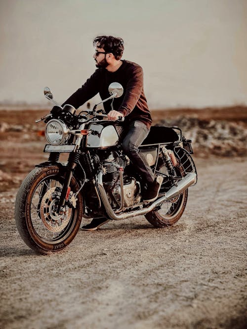 Man Sitting on Motorbike on Dirt Road
